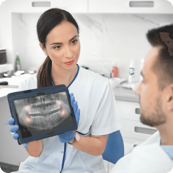 Dental team member and patient looking at all digital dental x rays