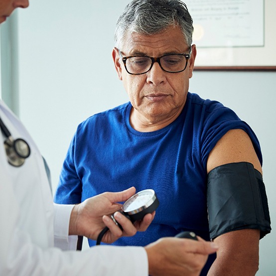 A man having his blood pressure checked by a doctor