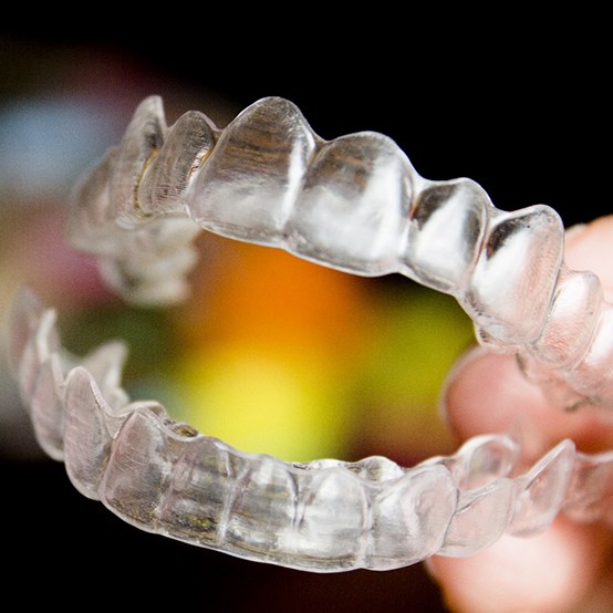 Person holding a set of clear aligners in Eugene