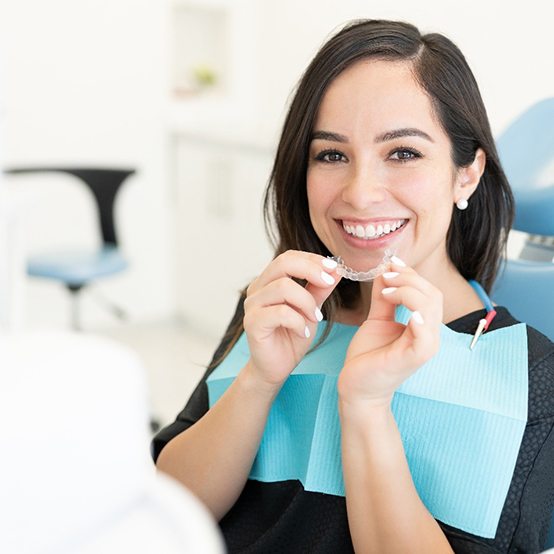 Woman in dental chair receiving clear aligners