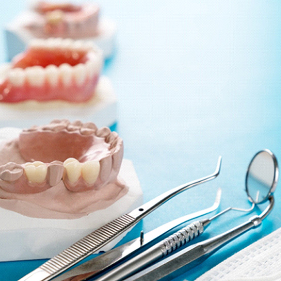 Different types of dentures in Eugene lined up on a blue table