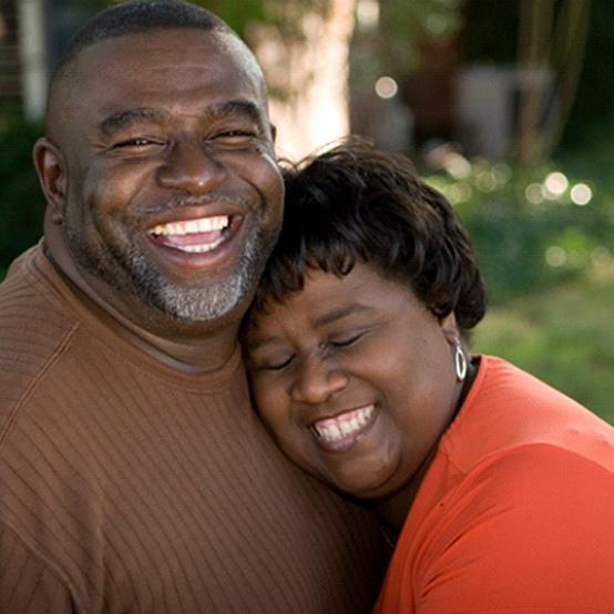 Laughing couple outside with dentures in Eugene