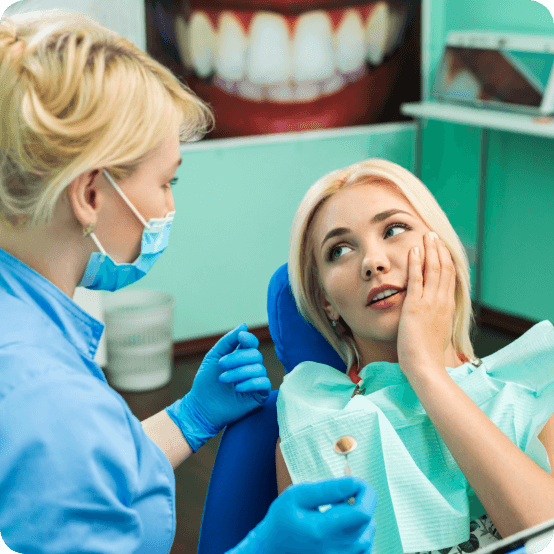 Woman holding cheek in pain discussing the cost of dental emergencies
