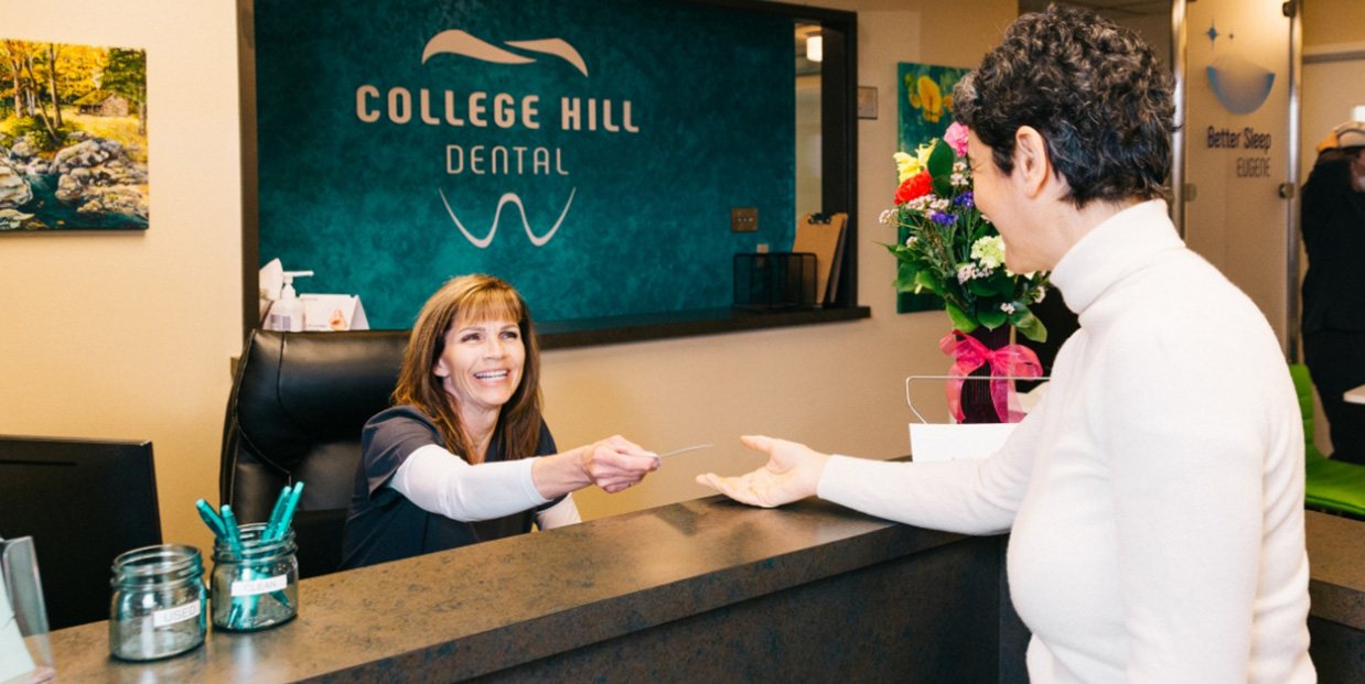 Eugene Oregon dental team member greeting patient at reception desk