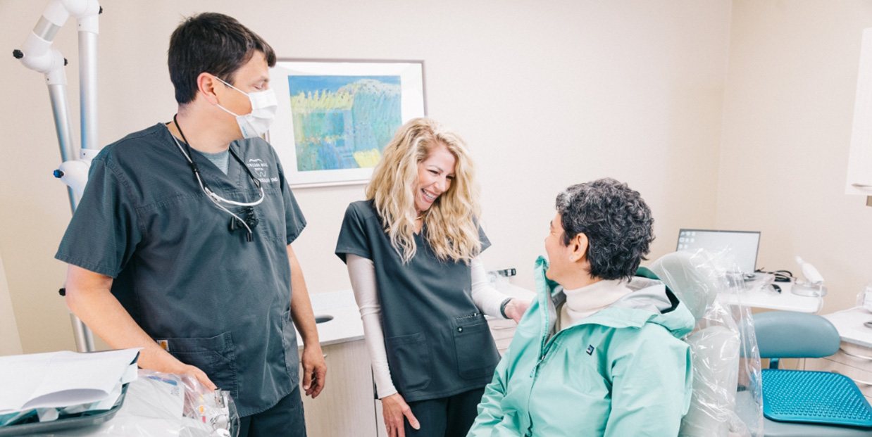 Dentist and dental team member talking to patient