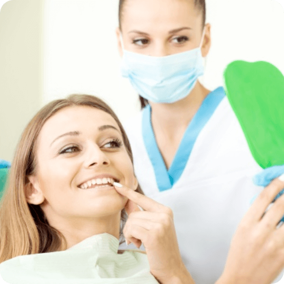 Dentist and patient looking at smile after dental bridge placement