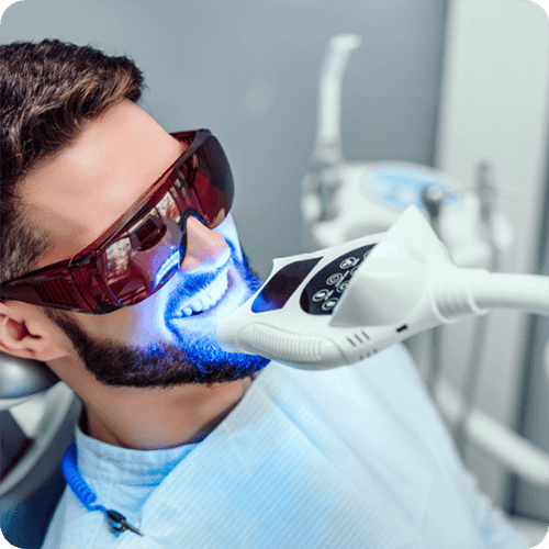 Man in dental chair getting his teeth professionally whitened