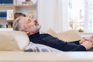 Senior man napping on sofa
